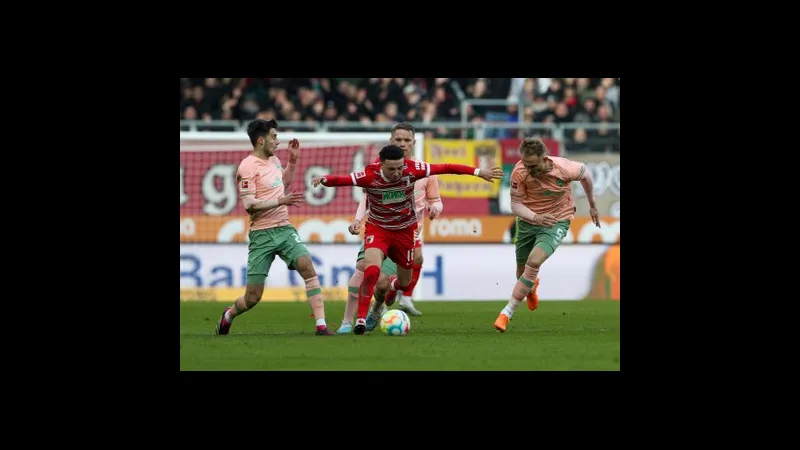 Cầu thủ Augsburg tiến vào vòng cấm Werder Bremen với bóng Cầu thủ Augsburg tiến vào vòng cấm Werder Bremen với bóng
